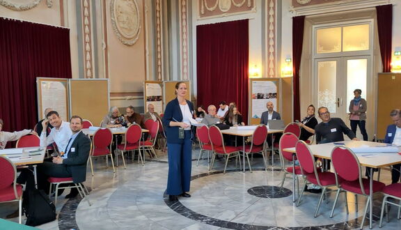 Sabine Rehbichler hält einen Vortrag mit vielen Teilnehmenden.