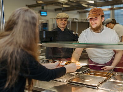 Links sieht man Oliver Horn. Er ist Fachanleiter in der FAB-Kantine und unterstützt Langzeitarbeitslose wie Nico Horn, den man rechts im Bild sieht.
